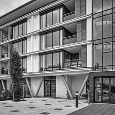 Espachstift: Fassade mit umlaufenden Balkonen und schrägen Stützen, Schwarzweißaufnahme