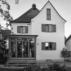 Saniertes Wohnhaus mit Wintergartenvorbau und Klappläden, Schwarzweißaufnahme