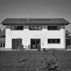 Wohnhaus mit Photovoltaikanlage auf dem Satteldach und Garten davor, Schwarzweißaufnahme