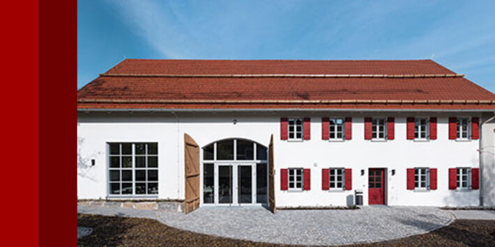 Dorfgemeinschaftshaus Gutenberg, weiß verputztes Gebäude mit rotem Ziegeldach und roten Fensterläden